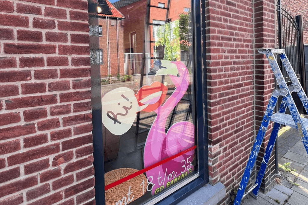 Roze flamingo met tekst op glazen raam